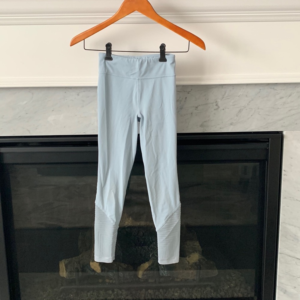 Light blue Athleta leggings with mesh and a pattern on the bottom of the pants.